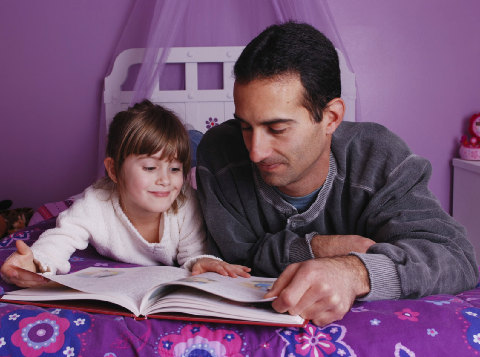 A father and daughter spend time together reading a  book